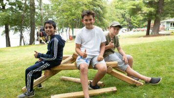 Boys sitting with thumbs up.